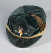 A green rugby representative cap bearing an embroidered springbok's head and dated 1924-28 on the