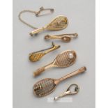 Five gilt metal tennis racquet brooches,  two with gilt metal tennis ball on strings, three with