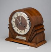 An Art Deco wooden cased mantel clock presented to the Arsenal footballer Jack Lambert, set with a