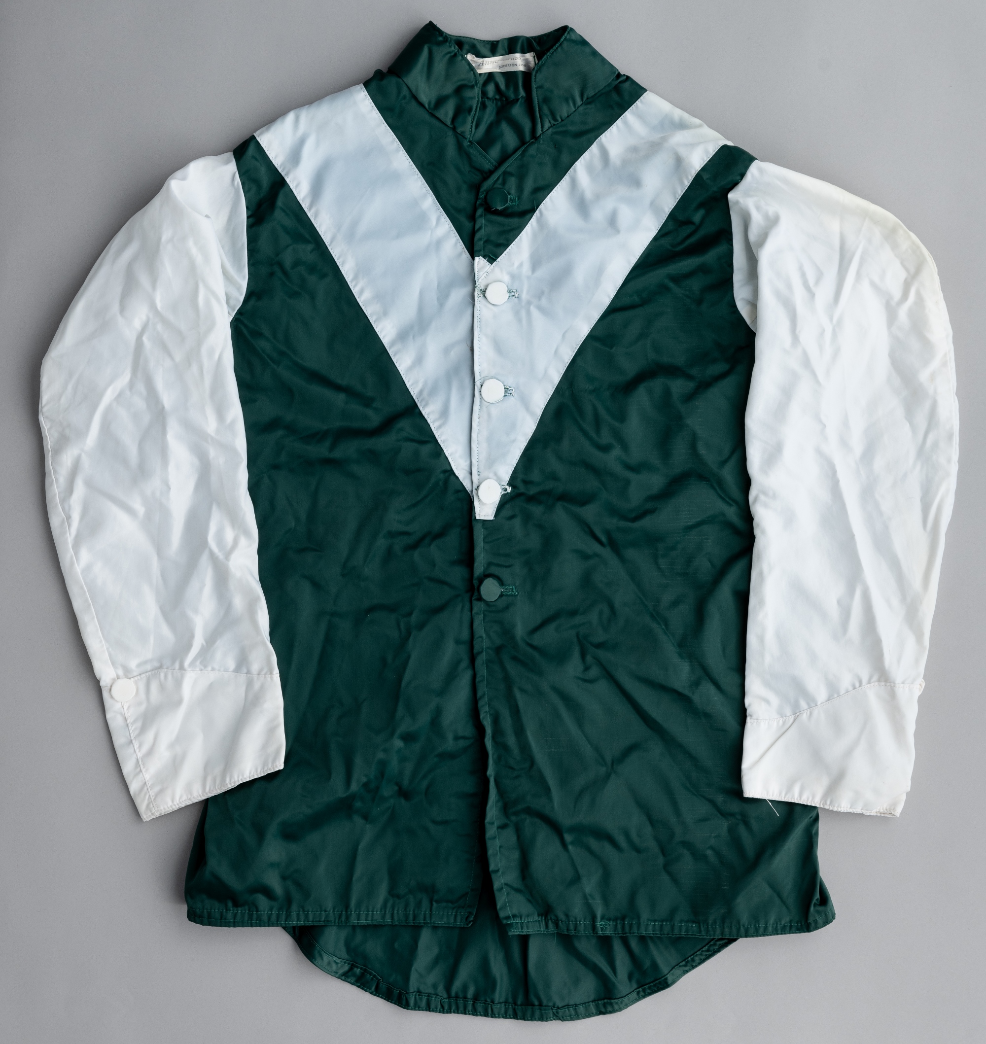 Wafic Said racing silks,  green jacket with white 'V' and sleeves, with makers label for Anne Cross,