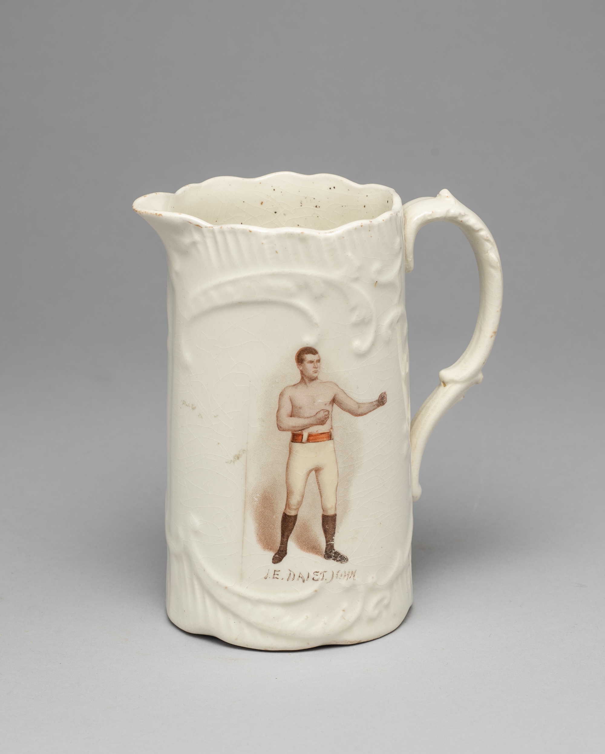 A white glazed pottery jug commemorating the Welsh heavyweight boxer Dai St. John circa 1900, colour