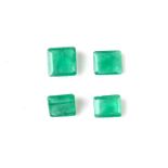 Four loose emerald cut emeralds.