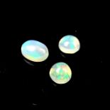 Three loose oval and circular cut opals.