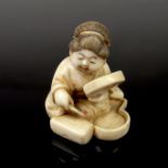 A Japanese carved ivory netsuke of a seated female, 19th century