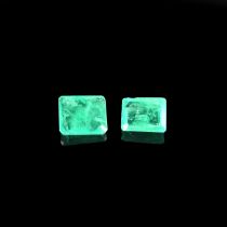 Two loose emerald cut emeralds.