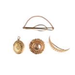 Two brooches, a tie clip and a locket.