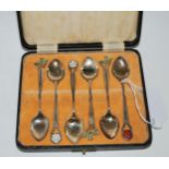 A cased set of six silver coffee spoons with enamel terminals, thistle, rose etc. Birmingham 1937