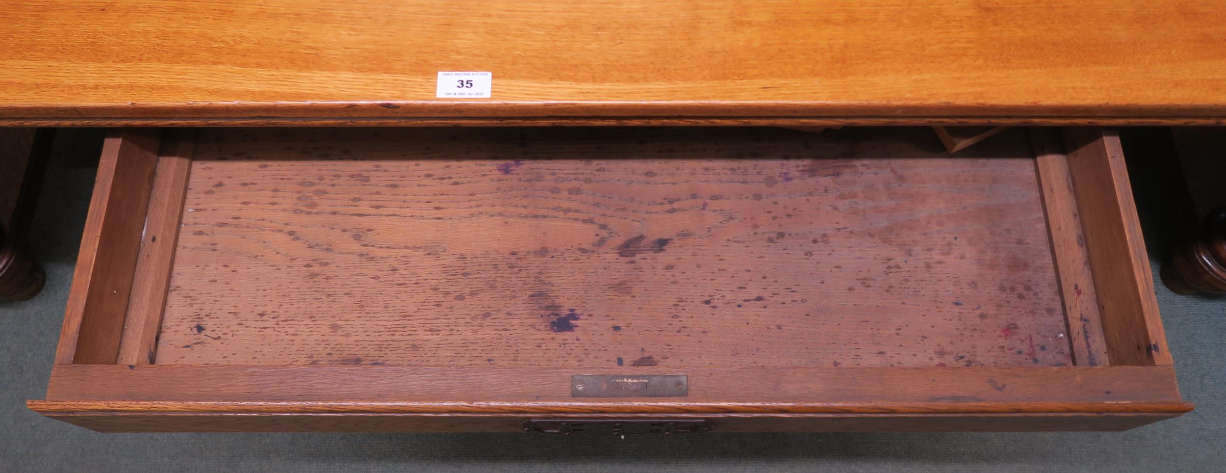 An early 20th century oak library table with a single drawer to both sides on stretchered baluster - Image 5 of 5
