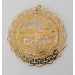 A brooch stamped 18k, with Greek key pattern border and iconic country scenes, diameter 5.2cm,