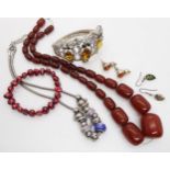 A string of cherry amber coloured beads, an owl bangle and other items Condition report: