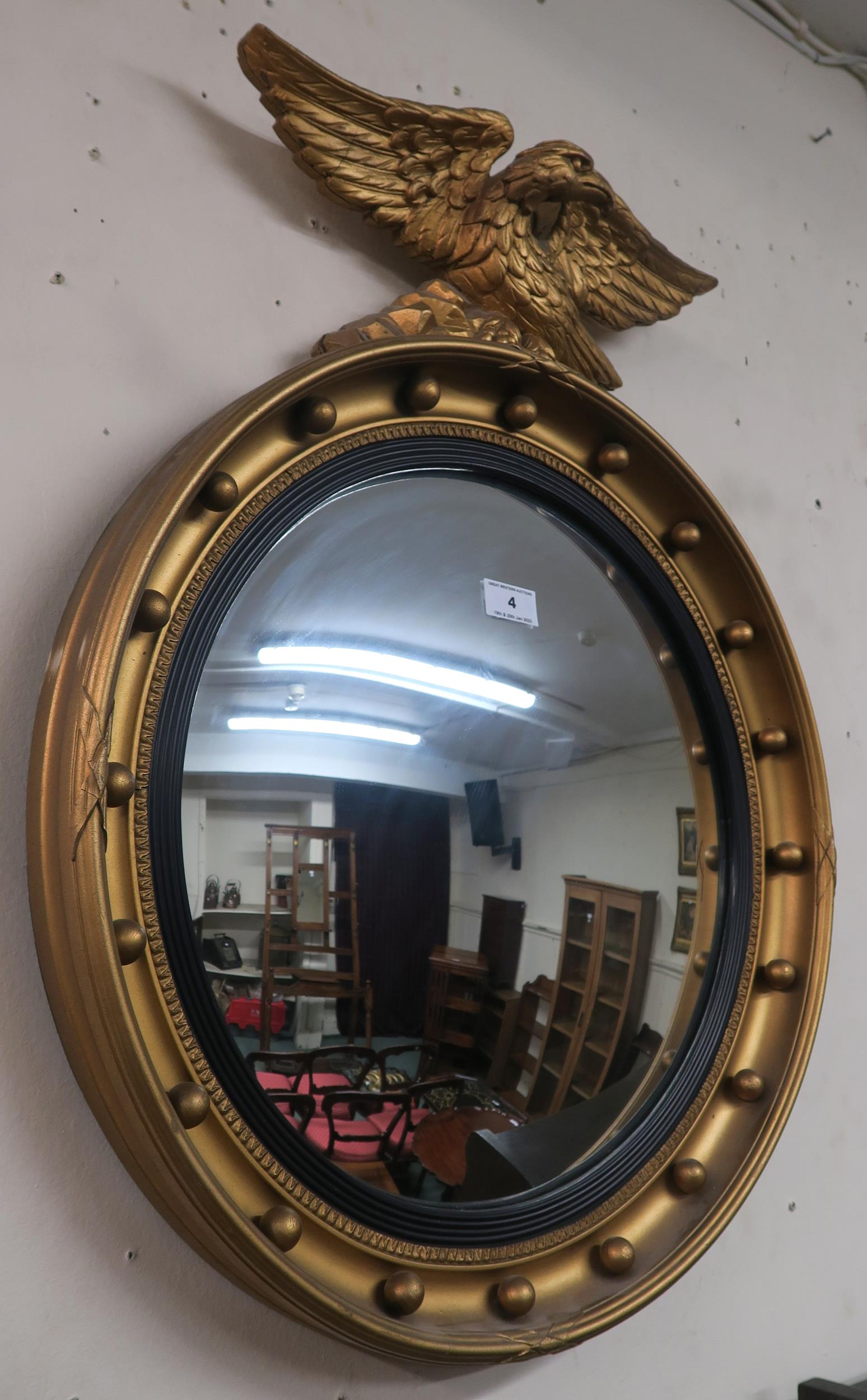 A 20th century gilt framed circular convex mirror with a gilt eagle to top 66cm high x 53cm wide