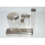 A lot comprising four assorted silver-topped dressing table jars and a silver-topped scent bottle (