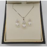 A 9ct white gold pearl and diamond pendant and chain, together with a pair of matching earrings,