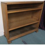 An early 20th century oak arts and crafts open bookcase on shaped bracket base 84cm high x 94cm wide