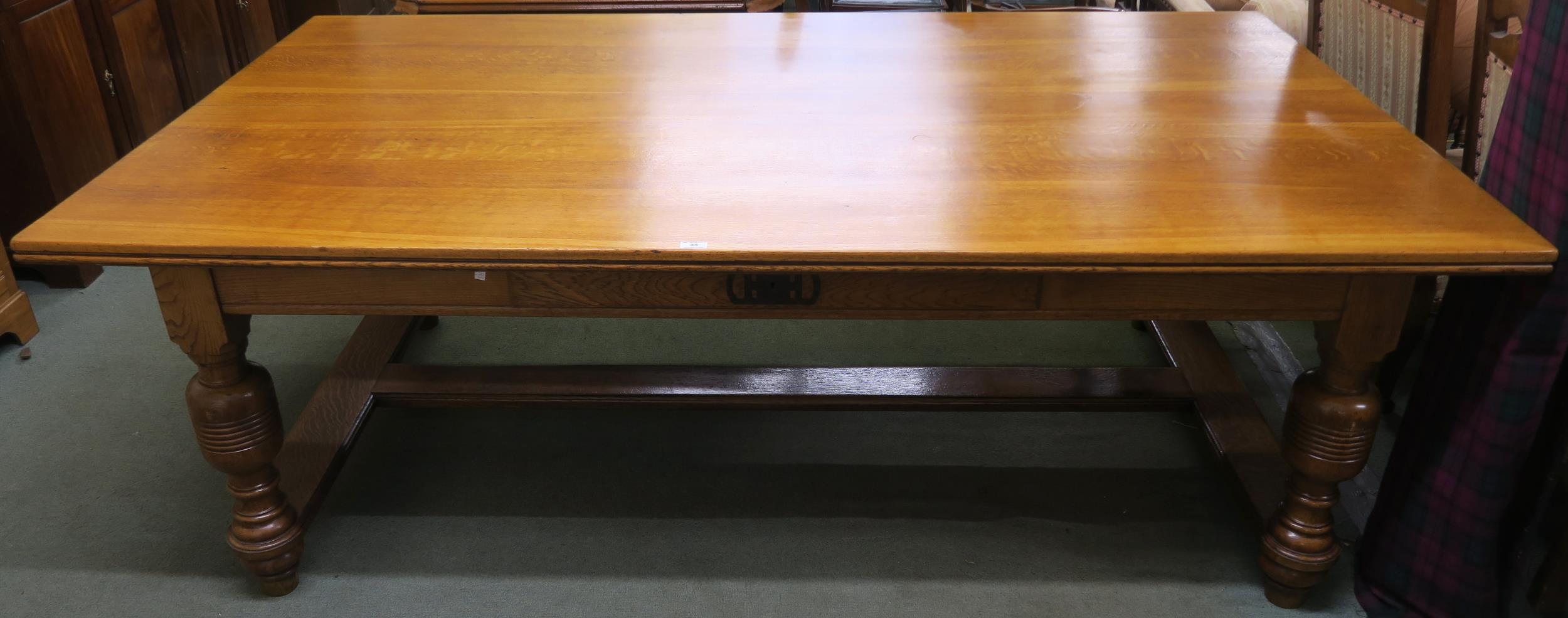 An early 20th century oak library table with a single drawer to both sides on stretchered baluster
