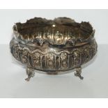 An 800 silver bowl, circular with foliate embossed decoration on three outswept feet 16 cm dia.