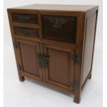 An early 20th century Chinese hardwood cabinet with three drawers above two cabinet doors drawers