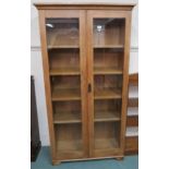 A 20th century oak glazed two door bookcase with four internal shelves 178cm high x 93cm wide x 38cm