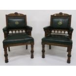 A pair of Victorian oak Gothic armchairs with green leather upholstery marked with the Kendal coat