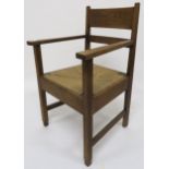An early 20th century arts and crafts oak framed armchair with rush seat 95cm high x 60cm wide x