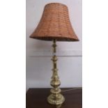 A 20th century cast brass table lamp with wicker lamp shade Condition report: Available upon