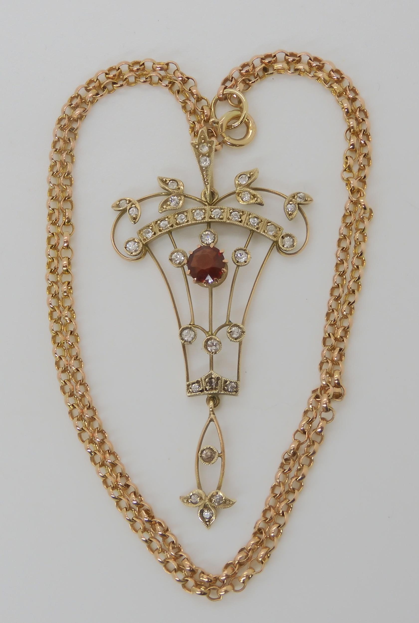 An Edwardian 9ct gold pendant set with garnet and clear gems, with a 9ct belcher chain, length 45cm,