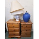 A lot comprising two pine three drawer bedside chests, two ceramic table lamps and a framed print (