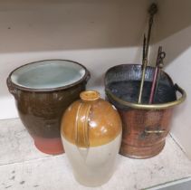 A hammered copper arts and crafts coal bib, assorted fire tools, stoneware jug and a stoneware urn