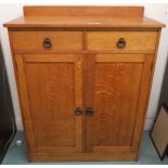 An early 20th century Taylor & Whitfield ltd oak two door cabinet with bronzed door furniture