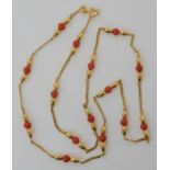 A 9ct gold chain set with coral and gold beads along its length. 48.5cm long, weight 8.2gms