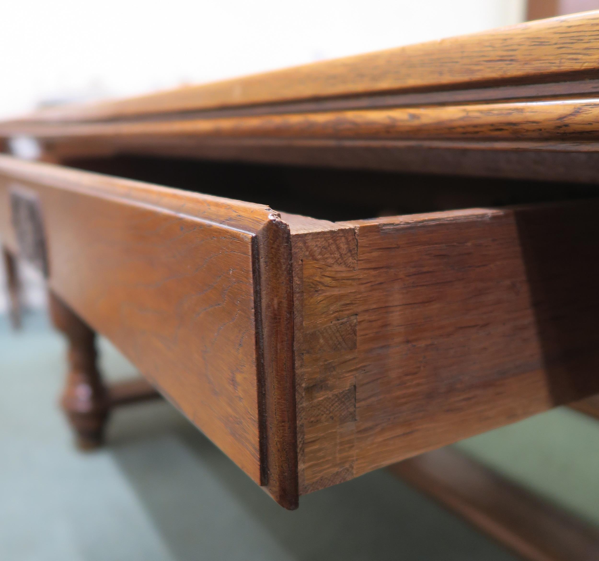An early 20th century oak library table with a single drawer to both sides on stretchered baluster - Image 4 of 5