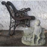 A reconstituted stone sculpture of a man on a bench and two cast metal garden bench ends (3)