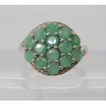 A 9ct white gold emerald and diamond cluster ring, set with estimated approx 0.15cts of diamonds,