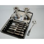A lot comprising  a pair of silver candlesticks, Birmingham 1919, a sauce ladle, Glasgow 1827 and