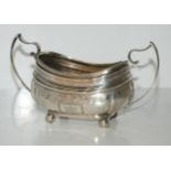 A silver sugar bowl, London 1813 of rounded rectangular form with floral engraved decoration and