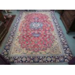 A red ground Najafabad rug with blue central medallion with beige spandrels and a blue border, 335cm