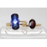 A 9ct gold garnet ring, size R1/2, together with a fancy cut blue glass gem set ring the shank