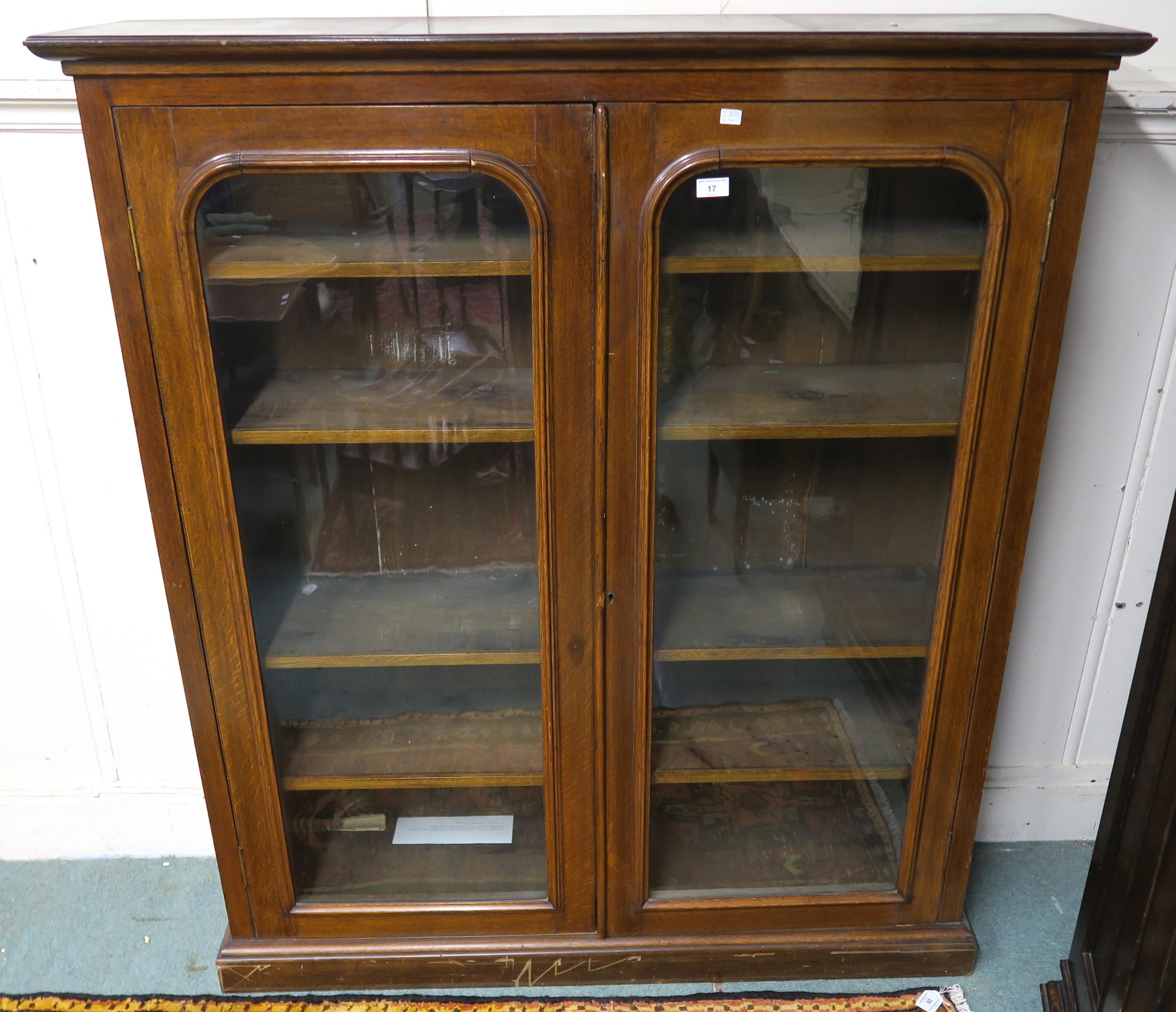 A 20th century stained oak glazed two door bookcase, 147cm high x 127cm wide x 32cm deep Condition