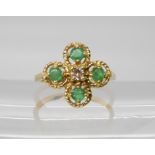 An 18ct gold diamond and emerald flower ring, set with an estimated approx 0.08ct brilliant cut,