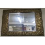 A Victorian brass framed arts & crafts bevelled glass rectangular wall mirror, embossed with