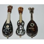 Three tortoiseshell and mother of pearl inlaid miniature instruments, two mandolins and guitar, 11cm