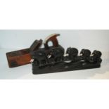 A graduated carved ebony set of elephants, 38cm wide and a vintage wood plane (2)  Condition