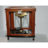 A balance scale by Thomson, Skinner & Hamilton in glazed case, 37cm wide Condition Report: