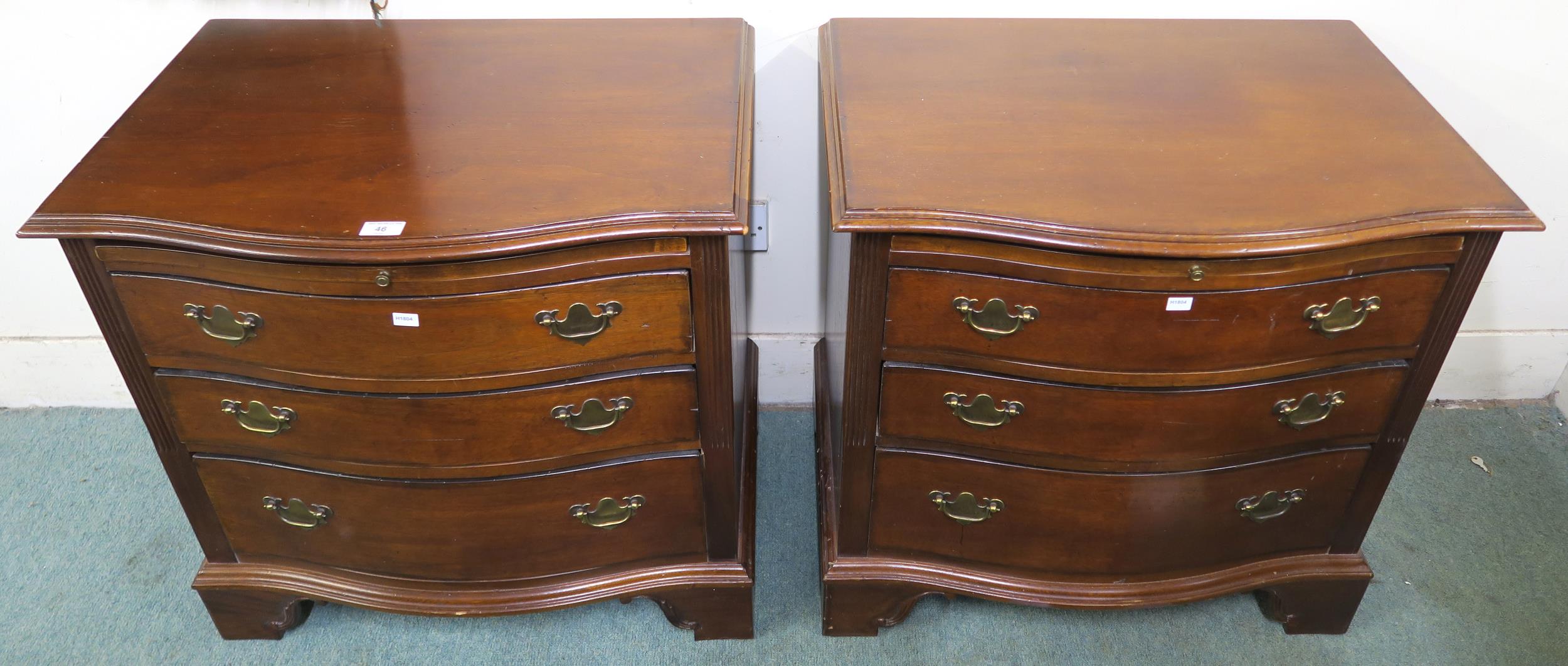 A pair of 20th century mahogany serpentine front three drawer chests, 69cm high x 71cm wide x 48cm