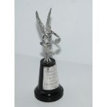 A silver car mascot, a winged female, London 1969 on socle base with silver plaque inscribed "