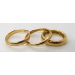 A heavy weight ladies 18ct wedding ring, size J1/2, a gents 18ct wedding ring size R1/2, and a