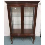 A 20th century mahogany glazed two door display cabinet with dentil cornice on cabriole supports,