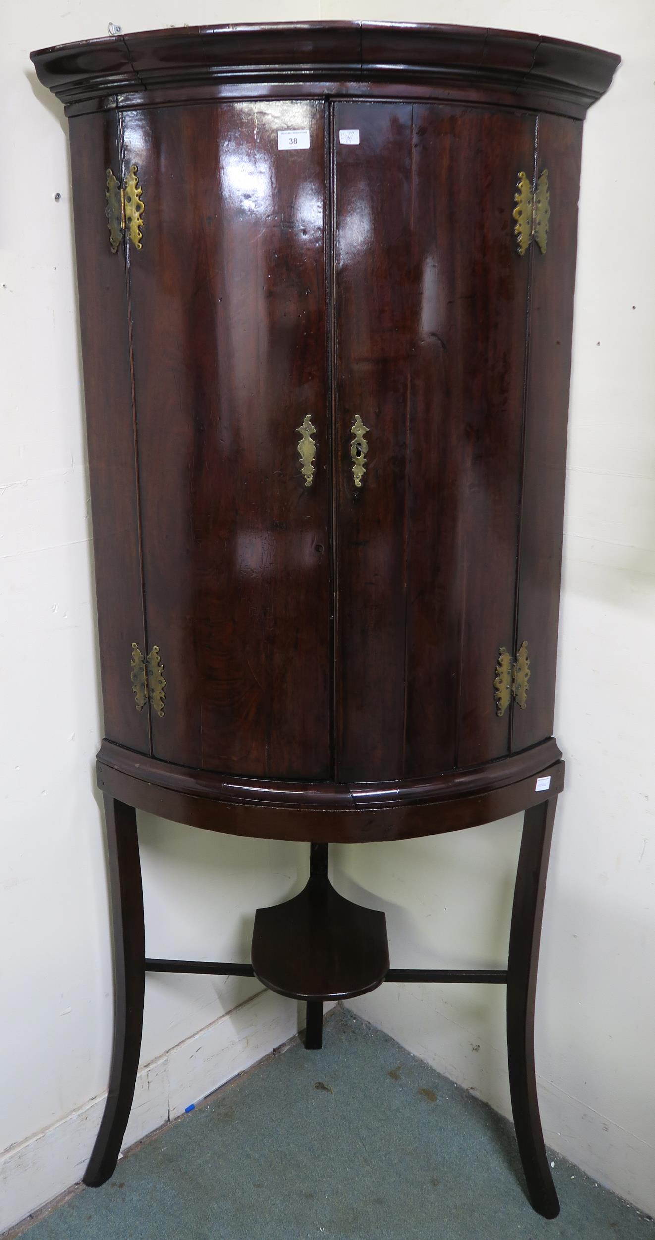 A Victorian stained oak dome front two door corner cabinet on stand, 179cm high x 80cm wide x 55cm