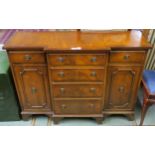 A 20th century mahogany breakfront side unit with four central drawers flanked by a single drawer