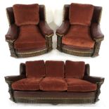 AN EARLY 20TH CENTURY OAK FRAMED THREE PIECE SUITE consisting three seater sofa 82cm high x 182cm